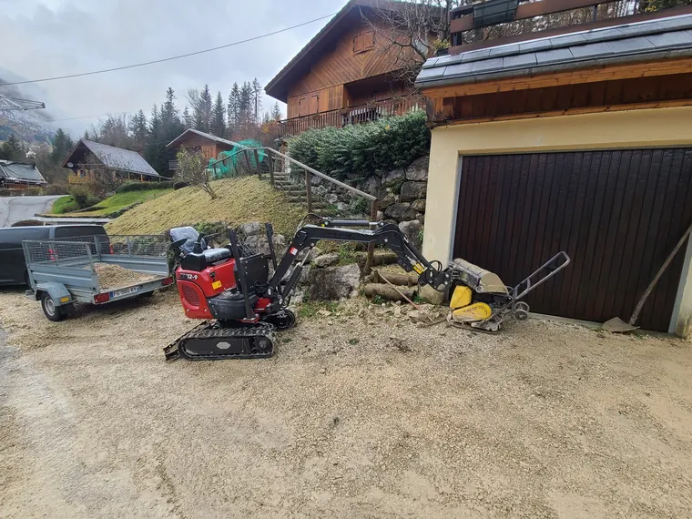 Mini-pelle 1T2 en intervention devant un garage